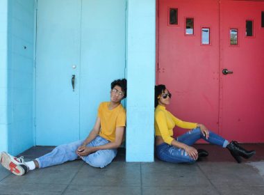 man in yellow polo shirt sitting beside woman in yellow shirt