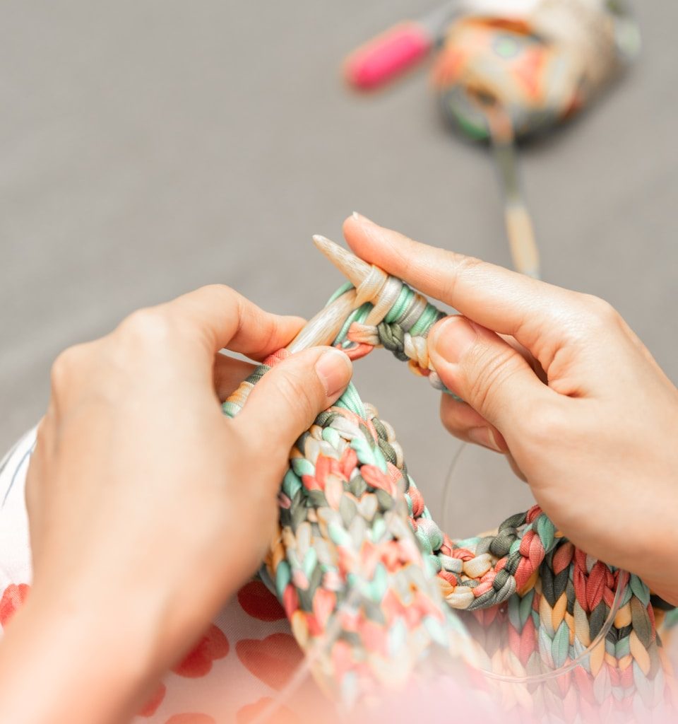 a woman is knitting a piece of fabric