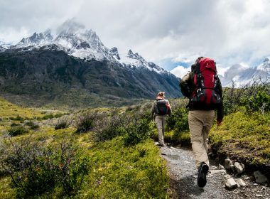 two person walking towards mountain covered with snow