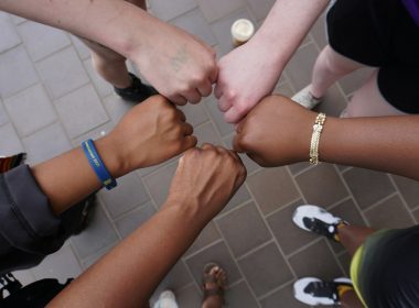 A group of people putting their hands together