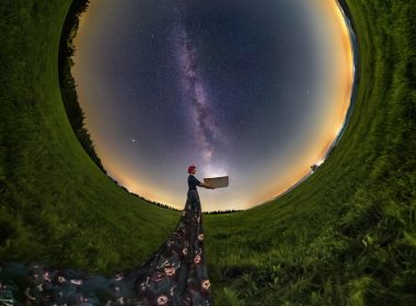 a person standing in a field looking at the stars