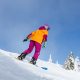 a person riding a snowboard down a snow covered slope