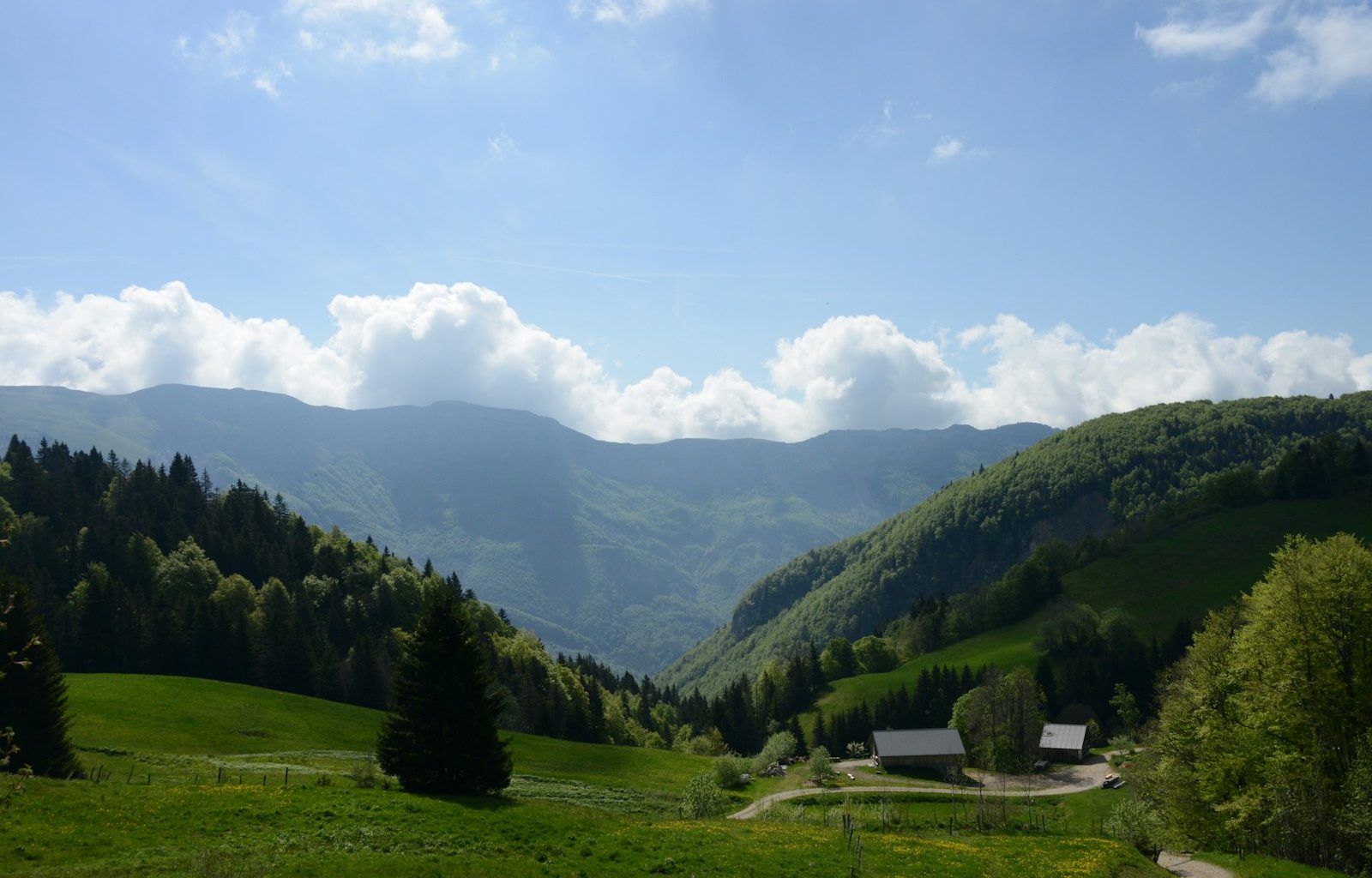 a scenic view of a mountain valley with a house in the foreground