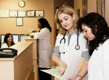 woman in white long sleeve shirt holding white printer paper