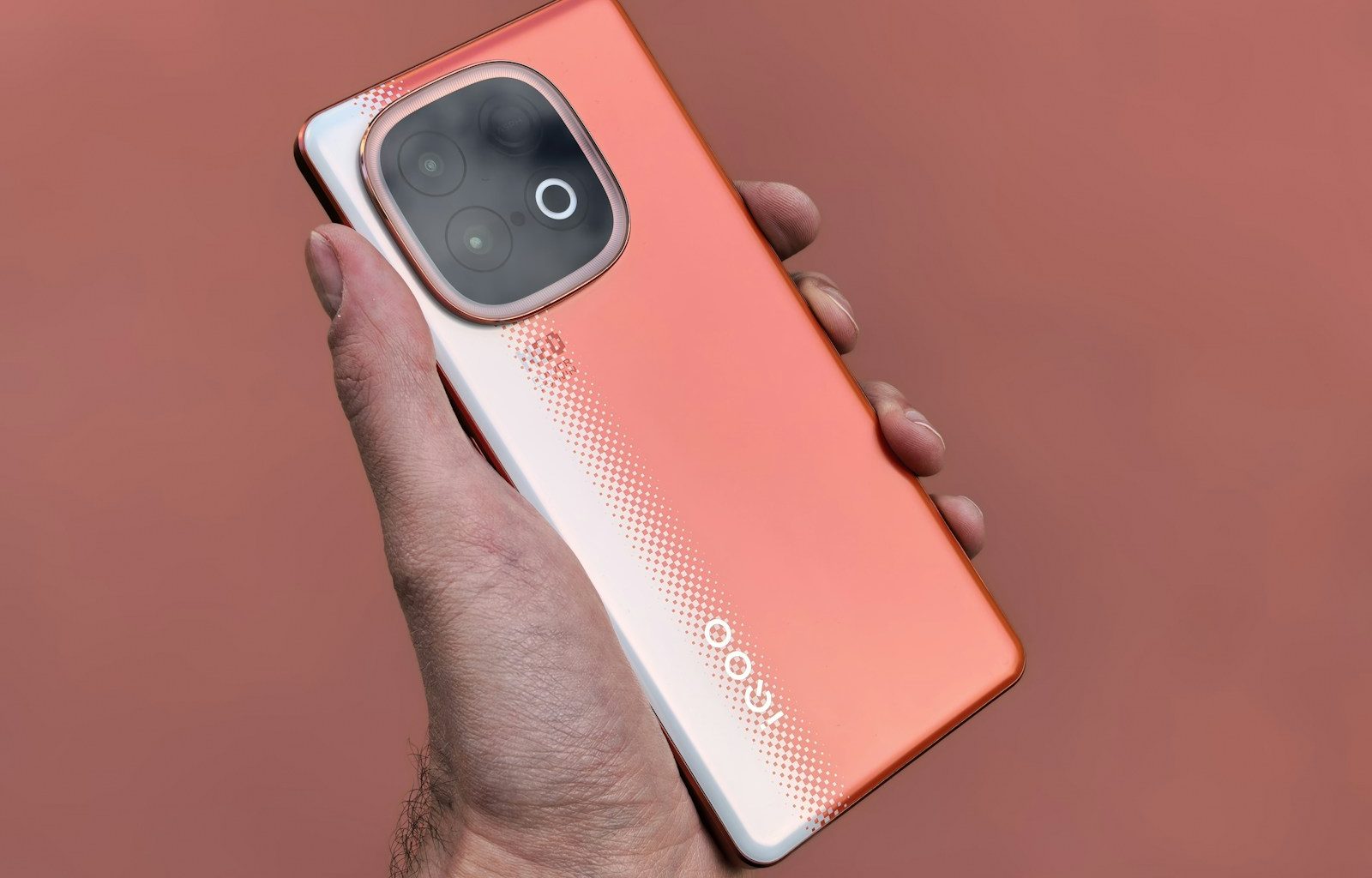 A person holds a unique, orange smartphone.