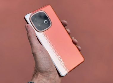 A person holds a unique, orange smartphone.