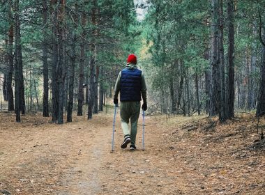 man in black jacket and black pants walking on brown dirt road in forest during daytime