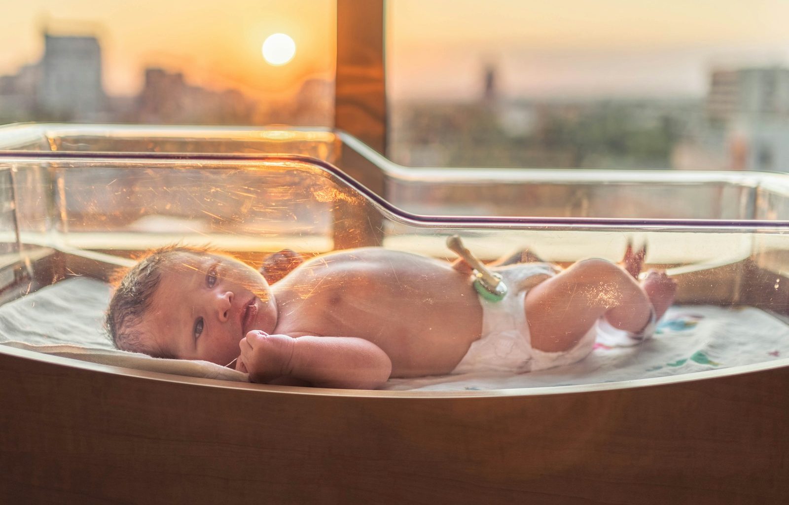 baby in white disposable diaper lying on white bathtub