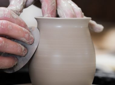 person holding white clay pot