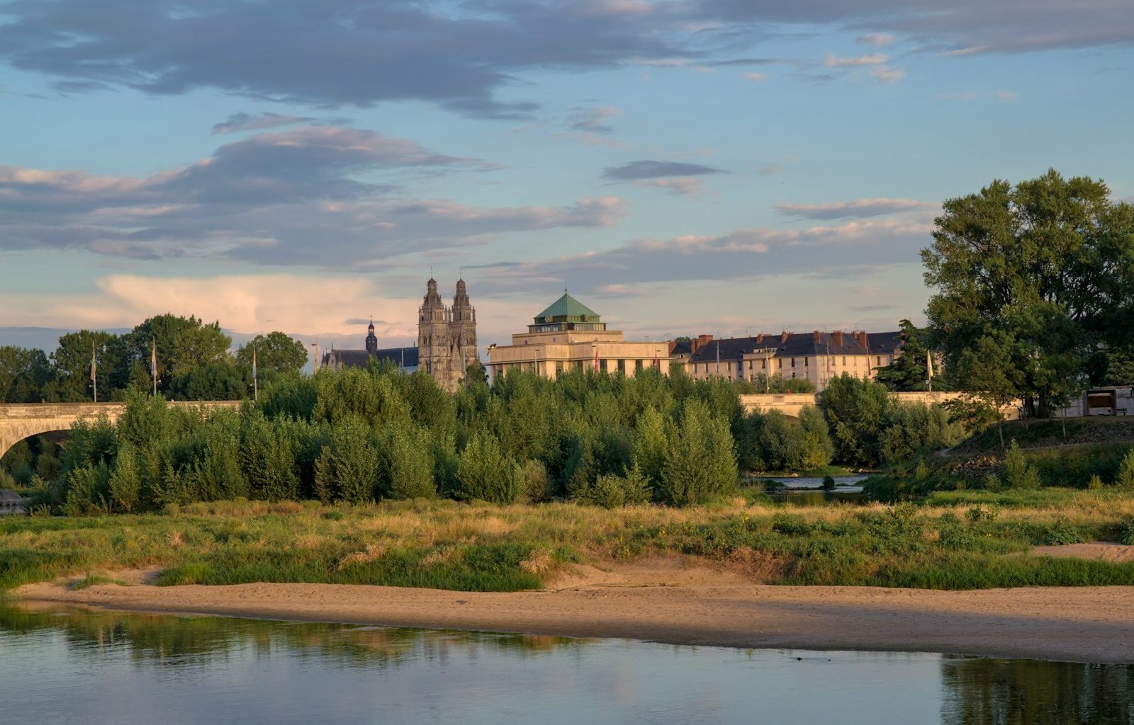 a large building sitting on top of a hill next to a river