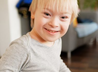 a young boy sitting in a chair with a smile on his face