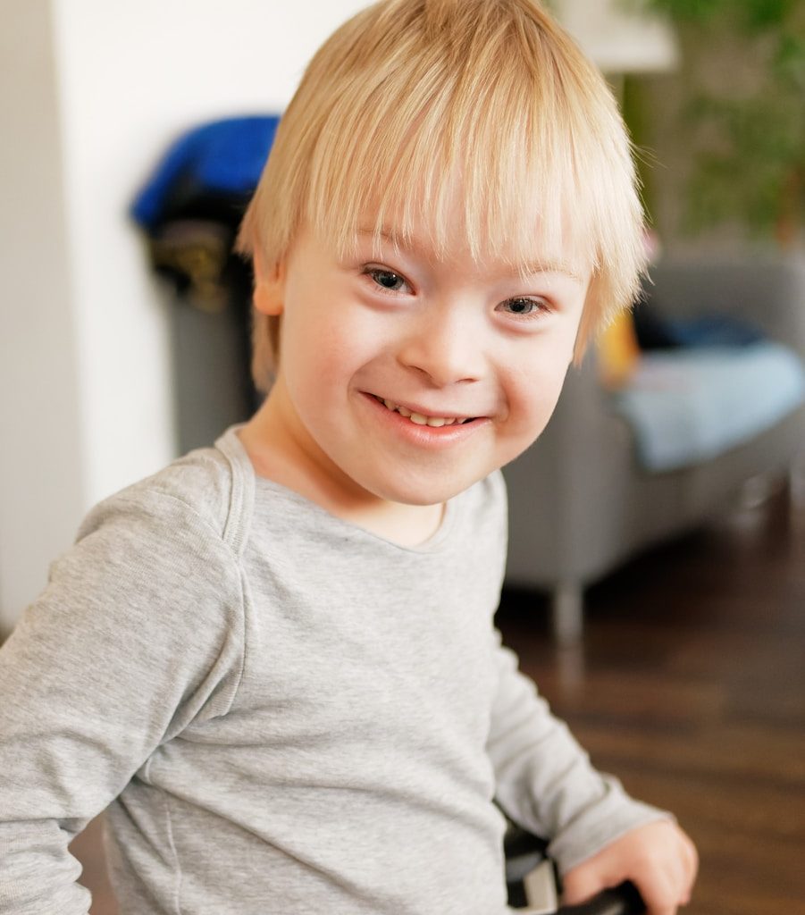 a young boy sitting in a chair with a smile on his face