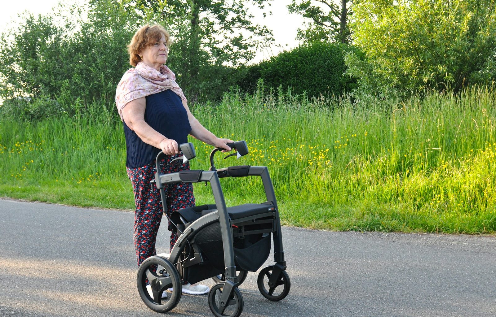 a woman pushing a walker down the street