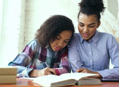 Mother and daughter studying together at a table.