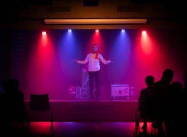 man in black shirt singing on stage