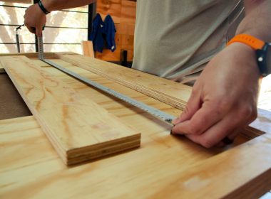 person in white shirt holding brown wooden table