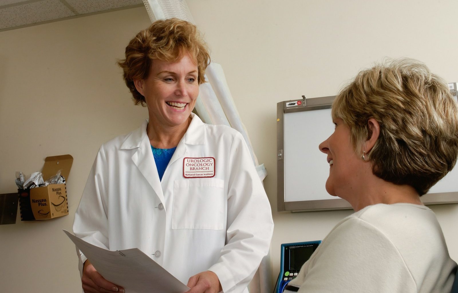 woman in white scrub suit holding gray laptop computer