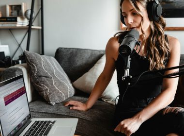 woman in black tank top sitting on couch using macbook