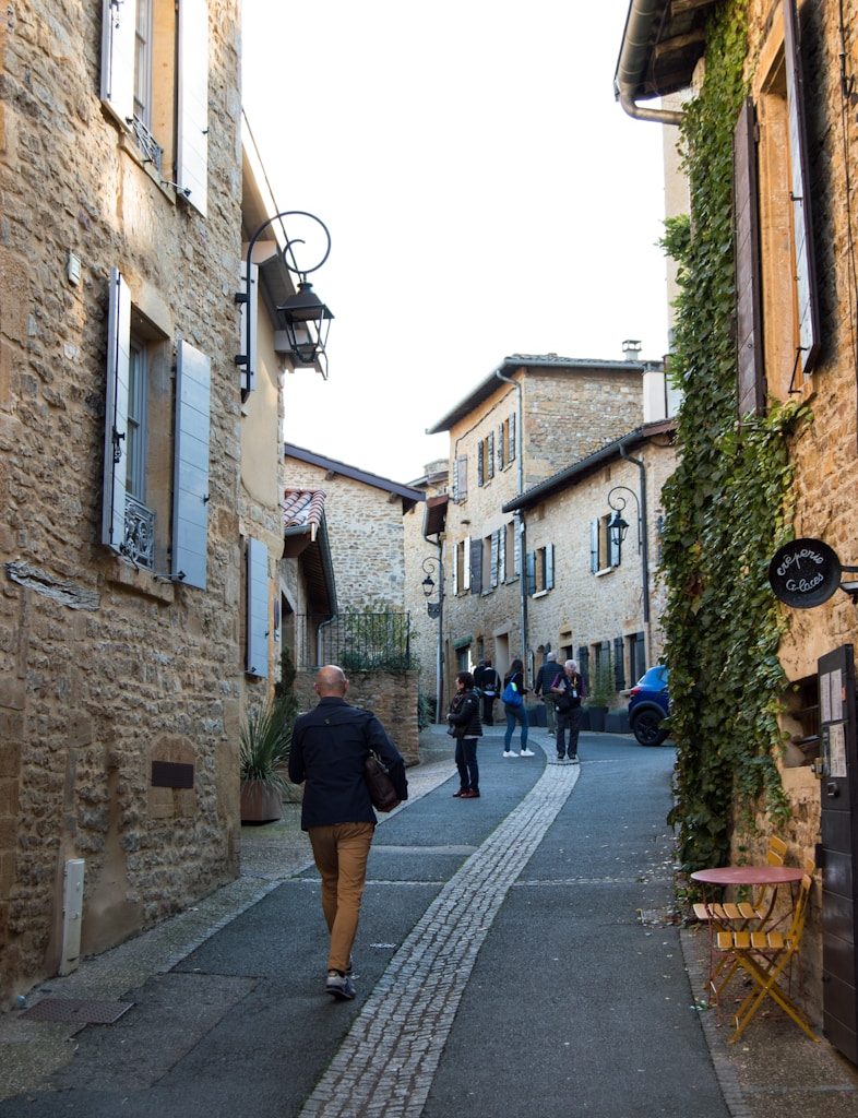 A woman walking down a street next to tall buildings
