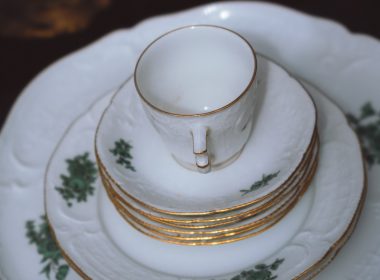a stack of white and gold china plates