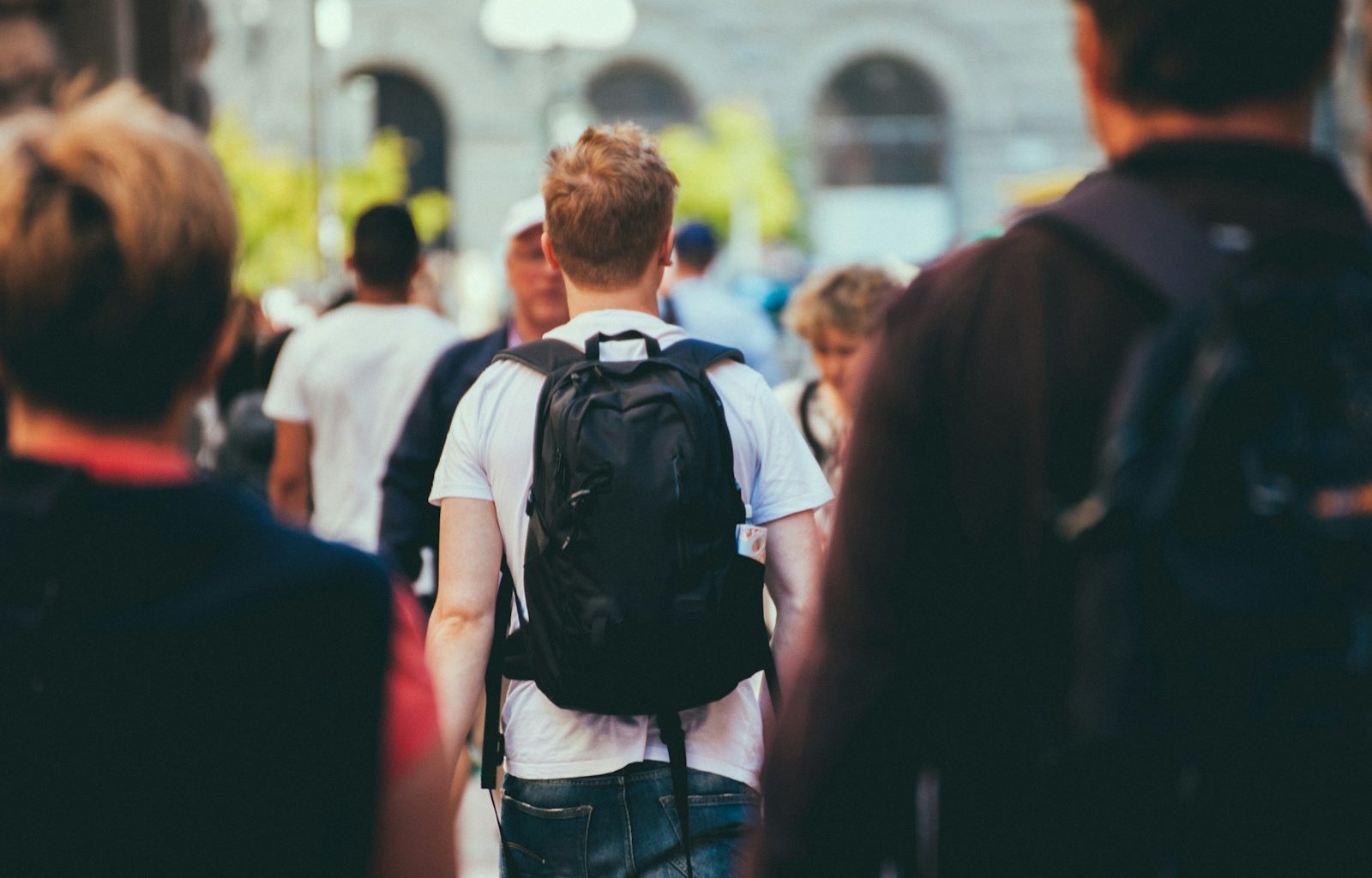 man in black and white shirt carrying black backpack