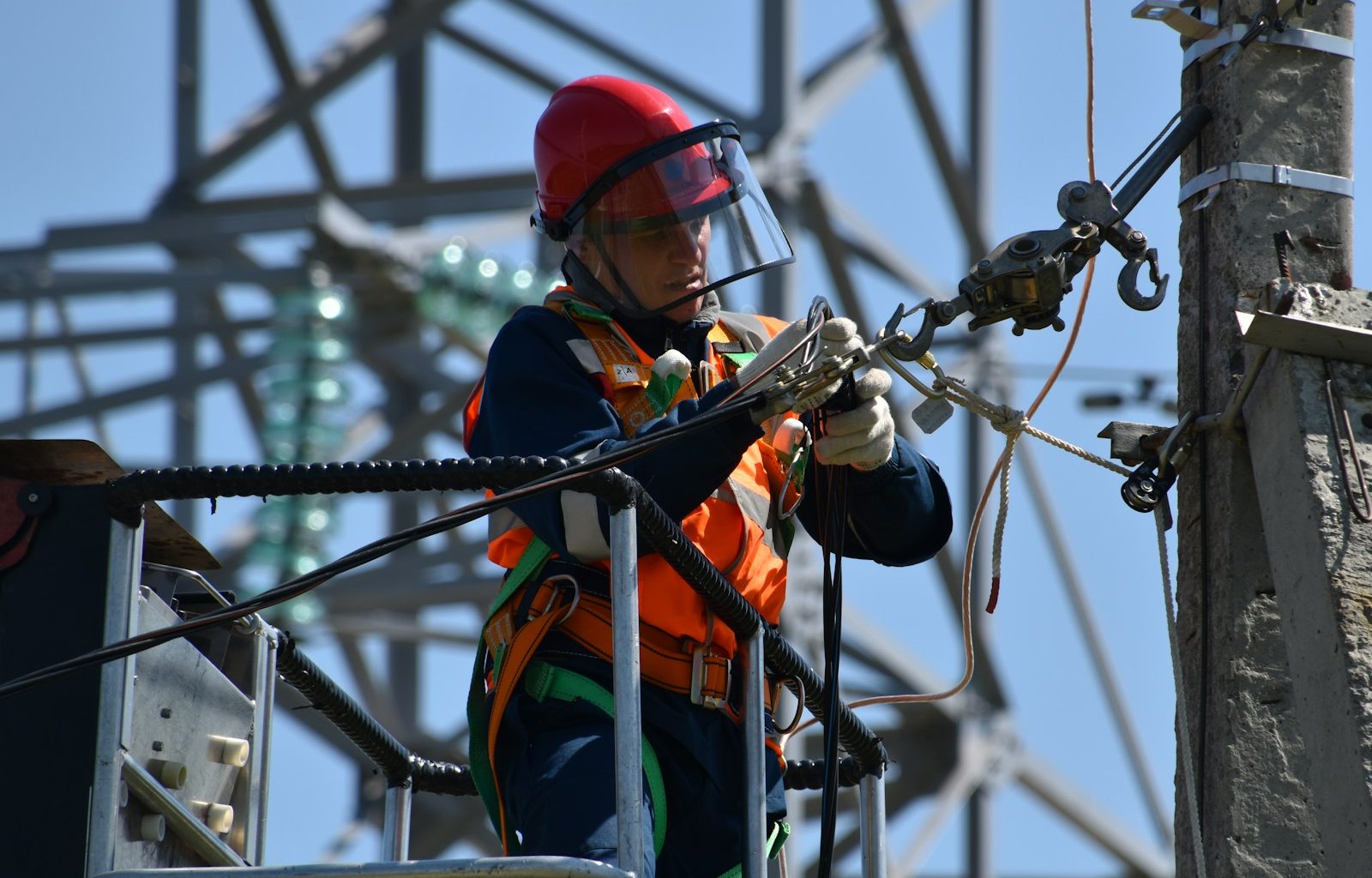 shallow focus photo of man fixing steel cable