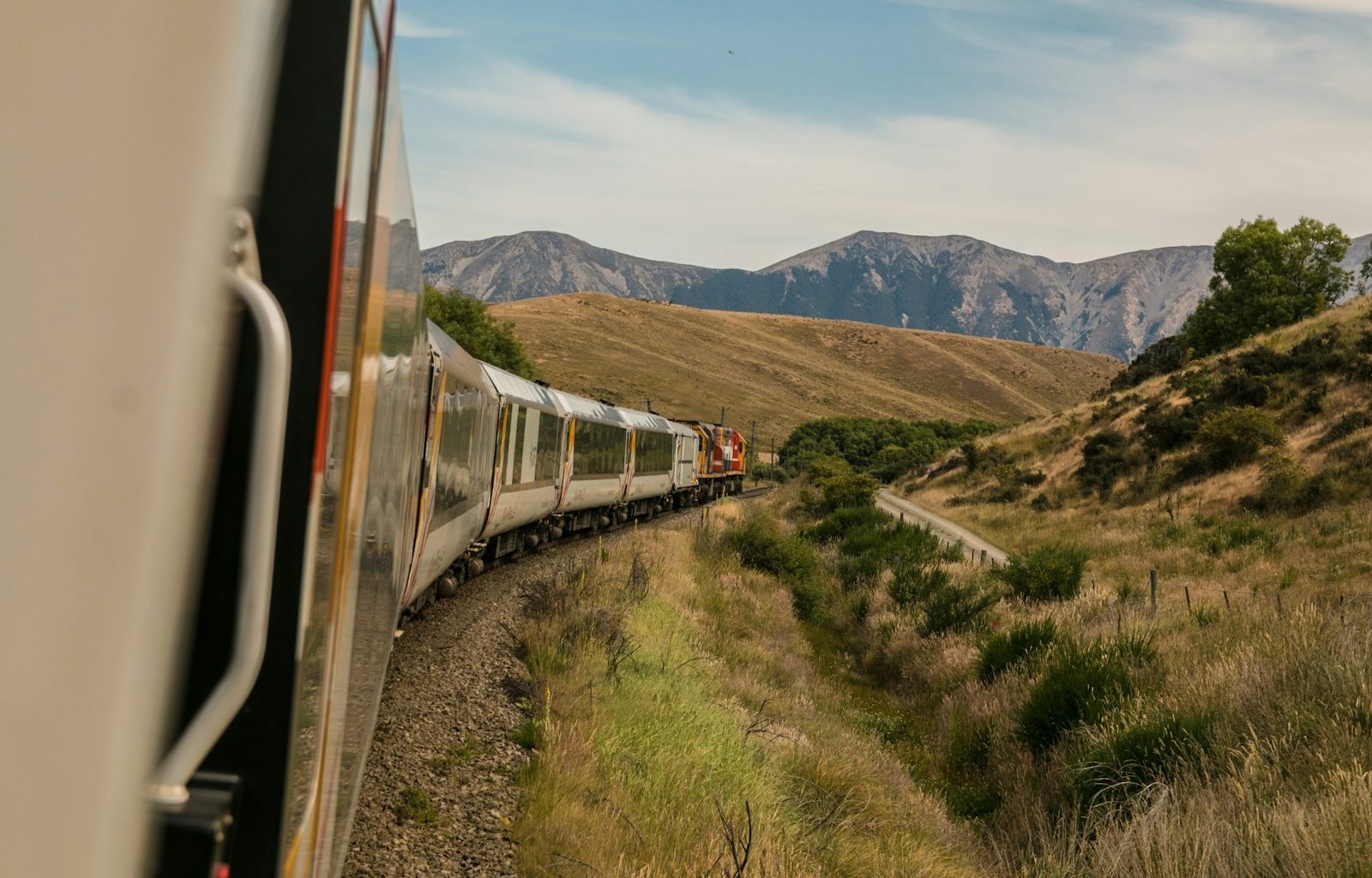 white train with the distance of mountain during daytime