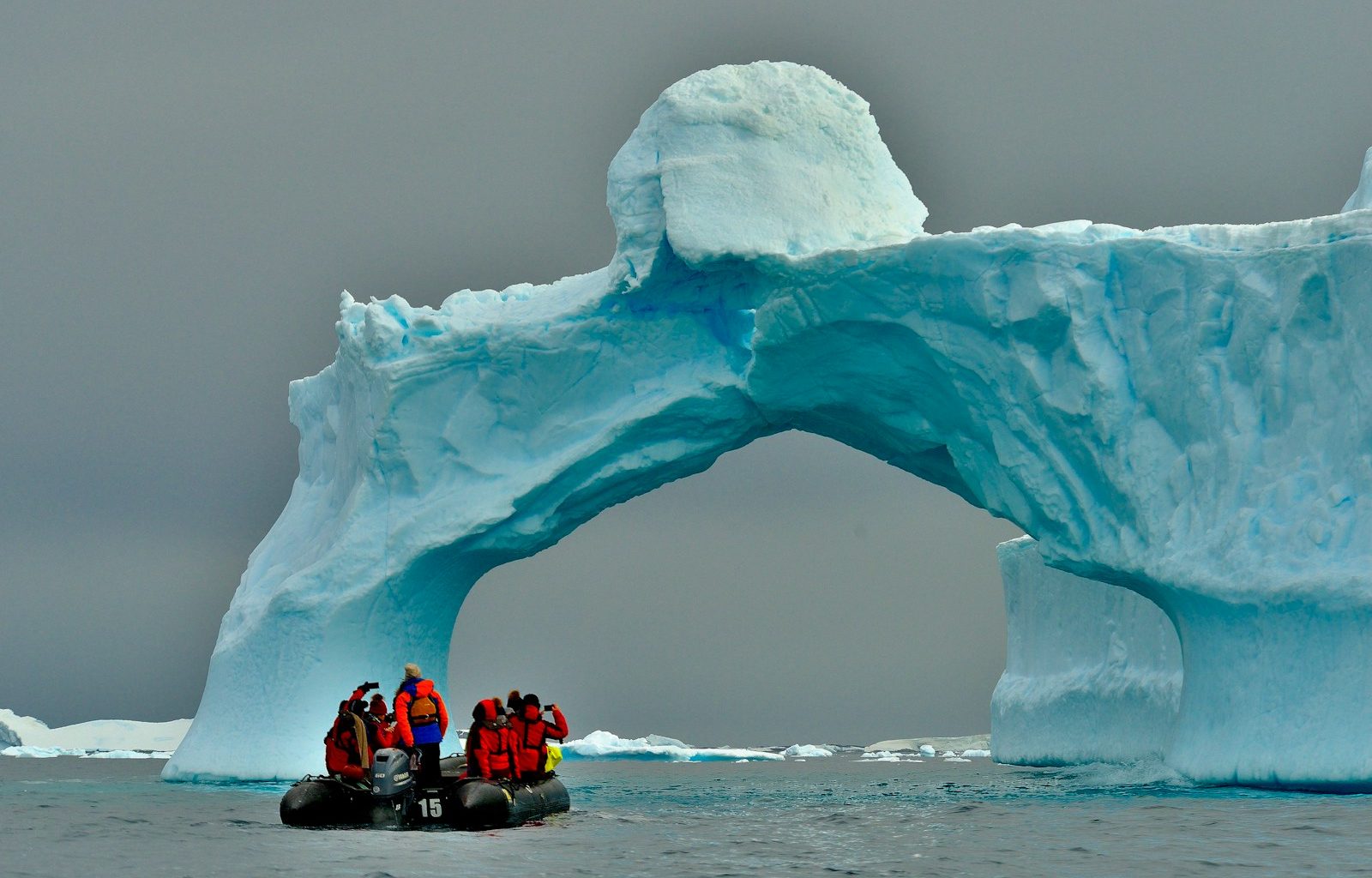 people sitting on ice formation during daytime