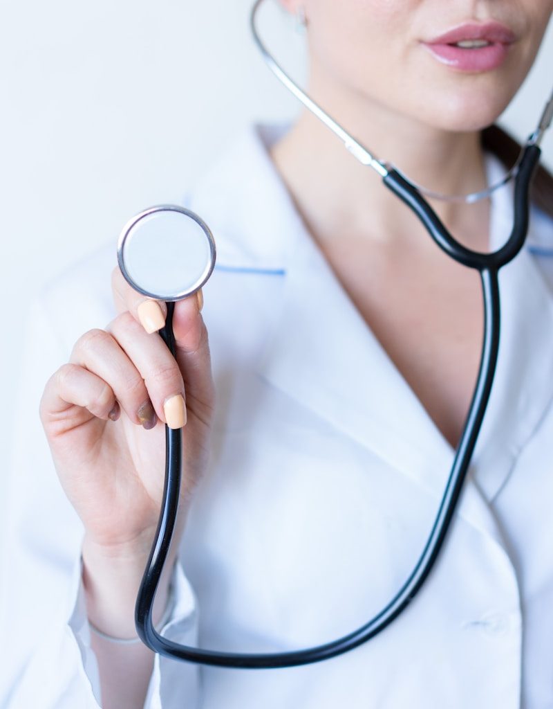 a woman in a white shirt holding a stethoscope