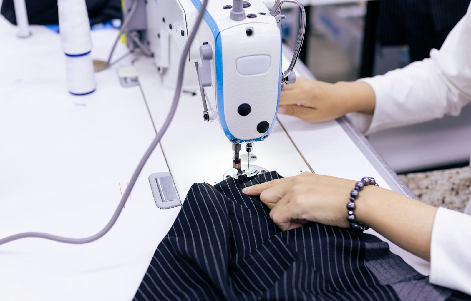 a woman using a sewing machine to sew clothes