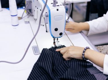 a woman using a sewing machine to sew clothes