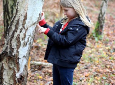woman in black jacket and black pants standing beside tree