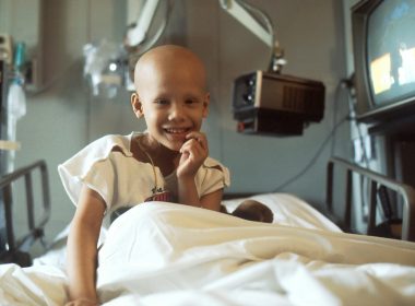 child sitting on bed