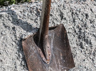 A shovel sitting on top of a pile of gravel