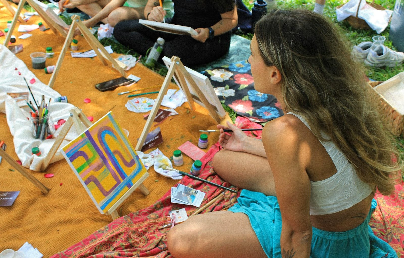 People painting outdoors at an art class.