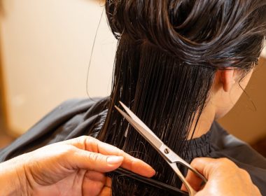 a woman cutting another woman's hair with scissors