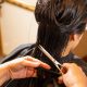 a woman cutting another woman's hair with scissors