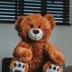 a brown teddy bear sitting on top of a desk