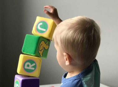 boy playing cube on white wooden table