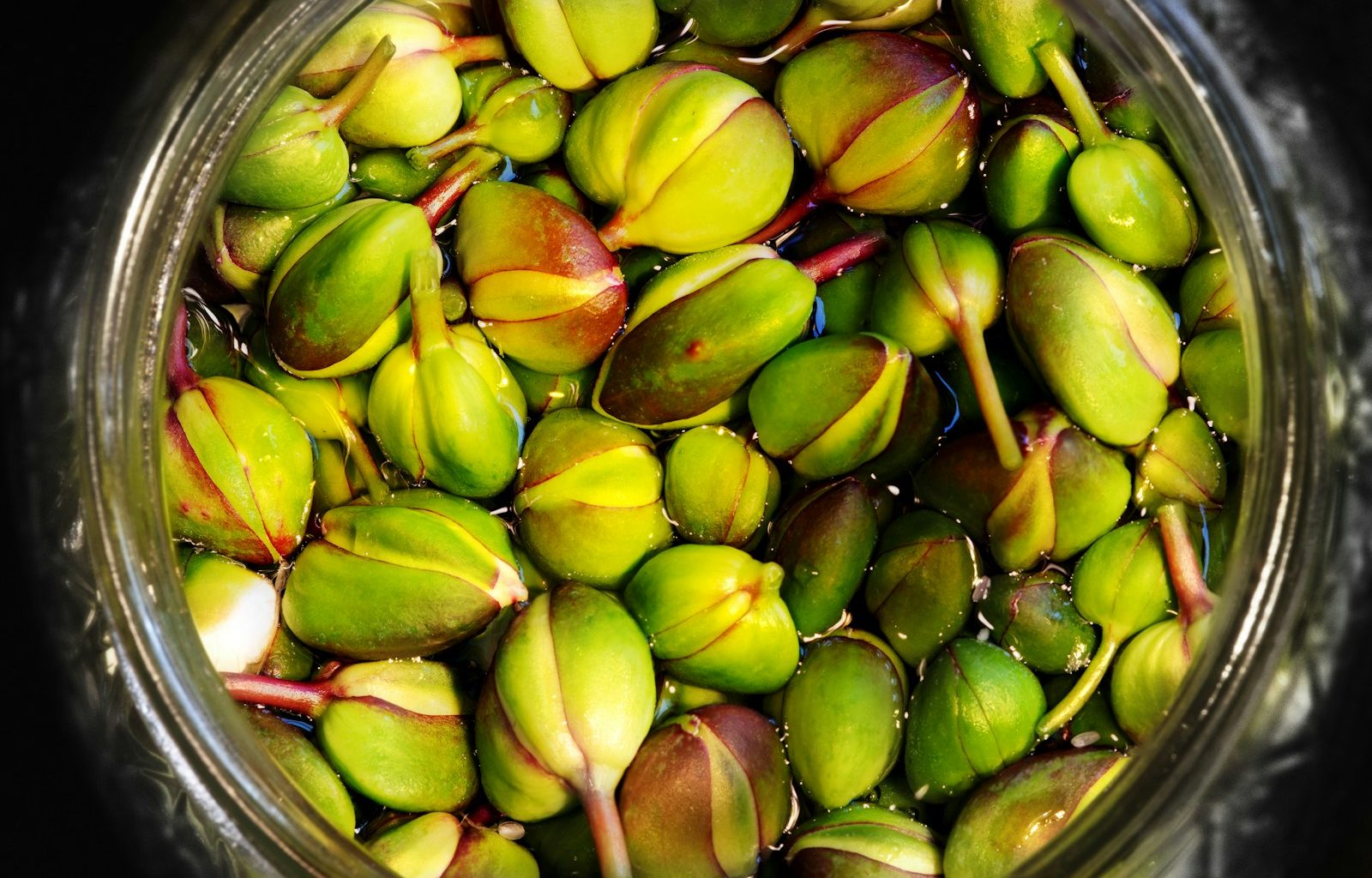green and brown fruit on clear glass bowl