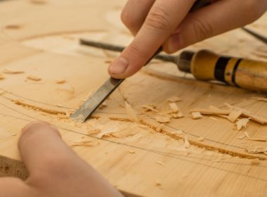 person using chisel while curving wood