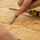 person using chisel while curving wood