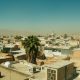 Overhead view of a dusty middle eastern city with palm trees.