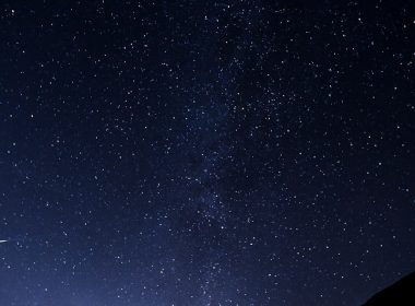 silhouette of man looking at milky way