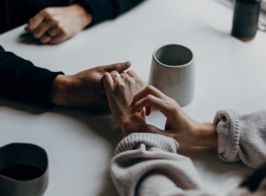 two people holding hands at table