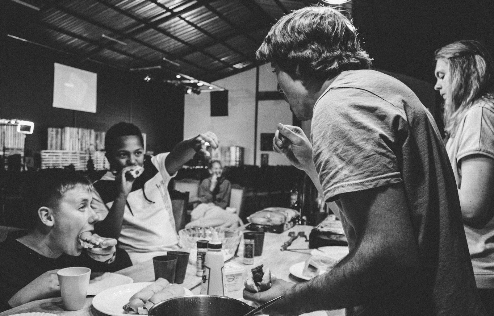 grayscale photography of people eating food