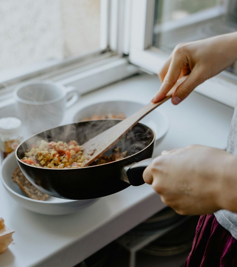 person holding black frying pan