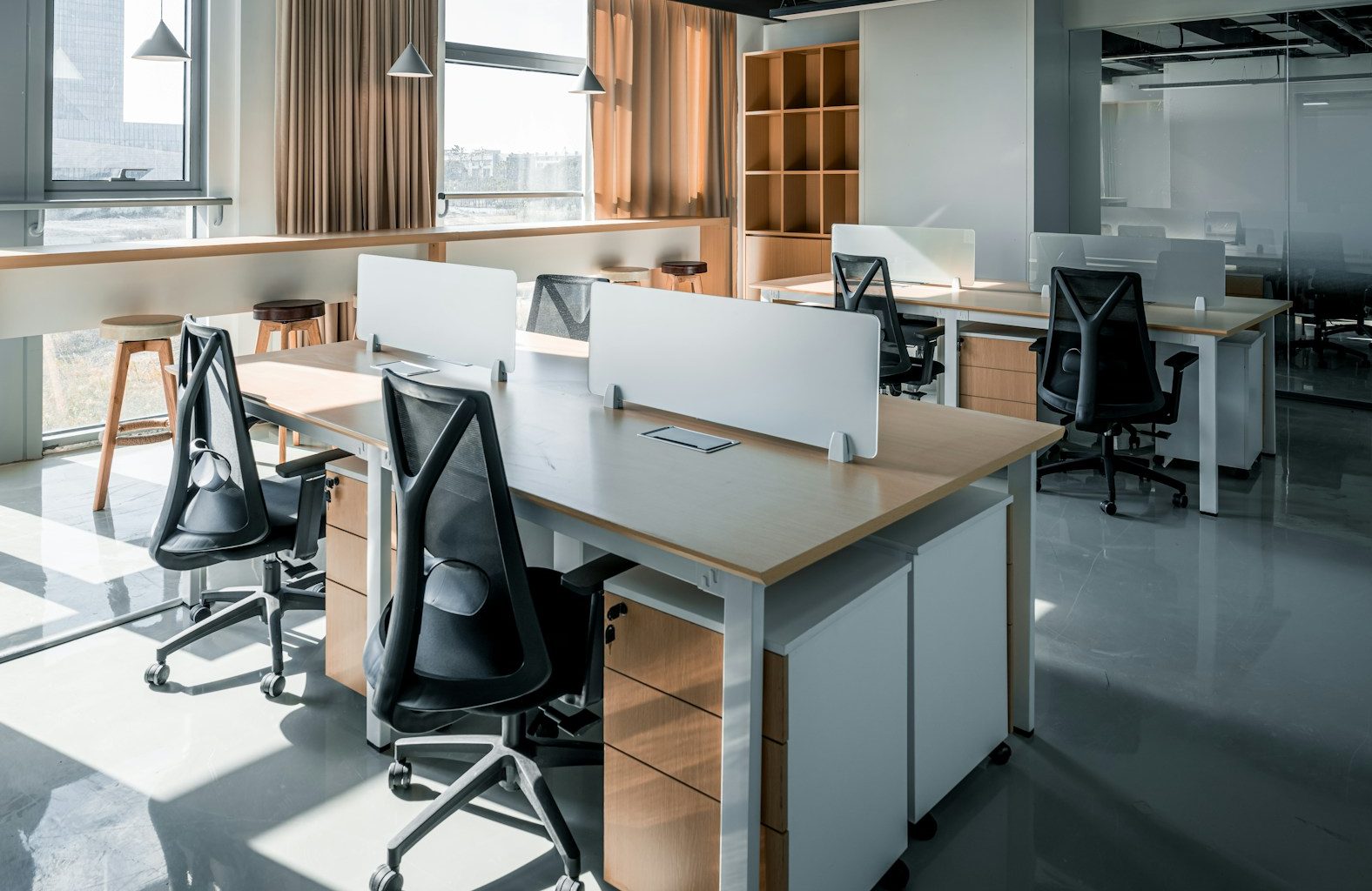 an office with a desk and chairs and a window