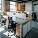 an office with a desk and chairs and a window