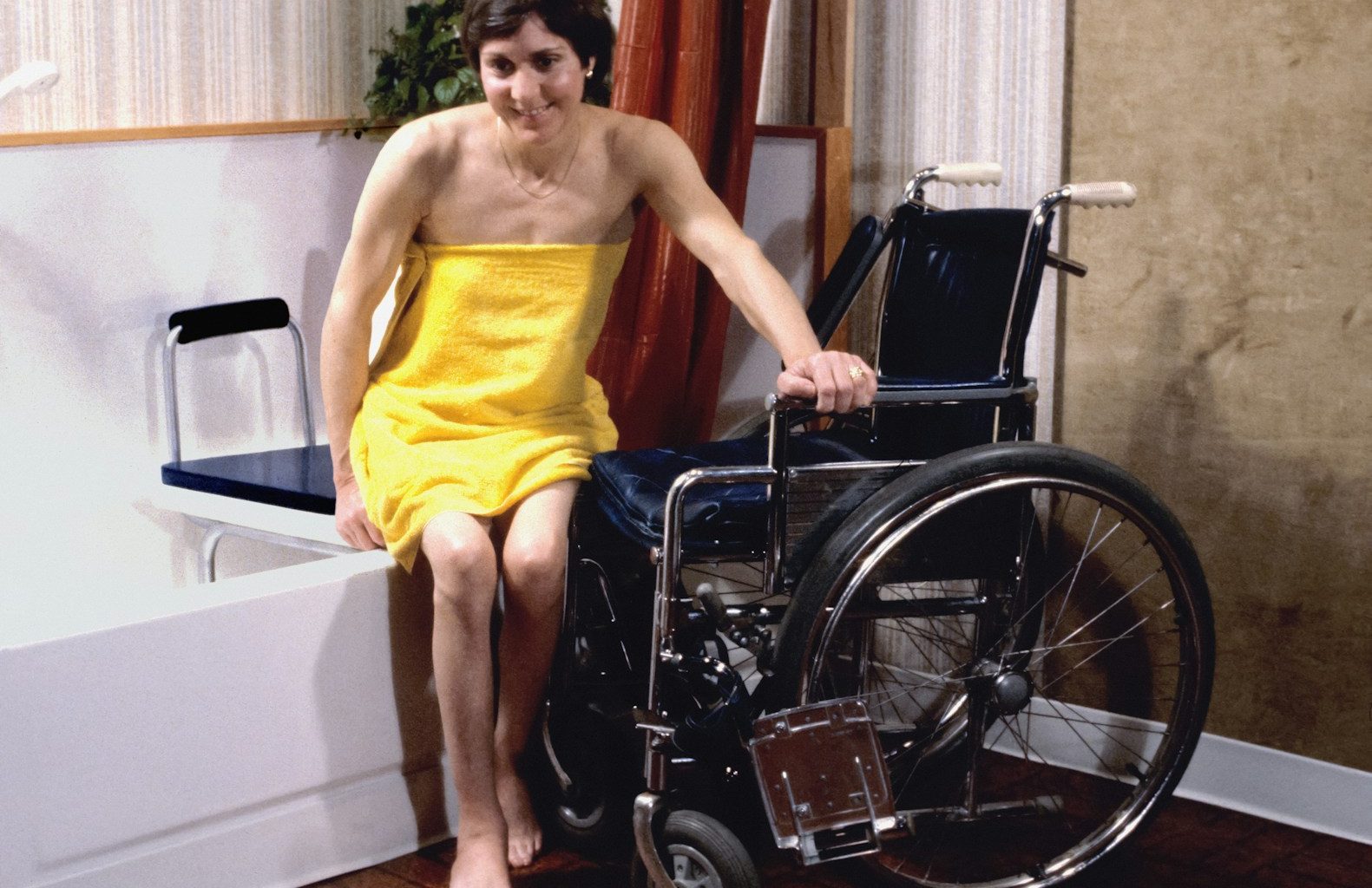 a woman in a yellow towel sitting in a wheelchair